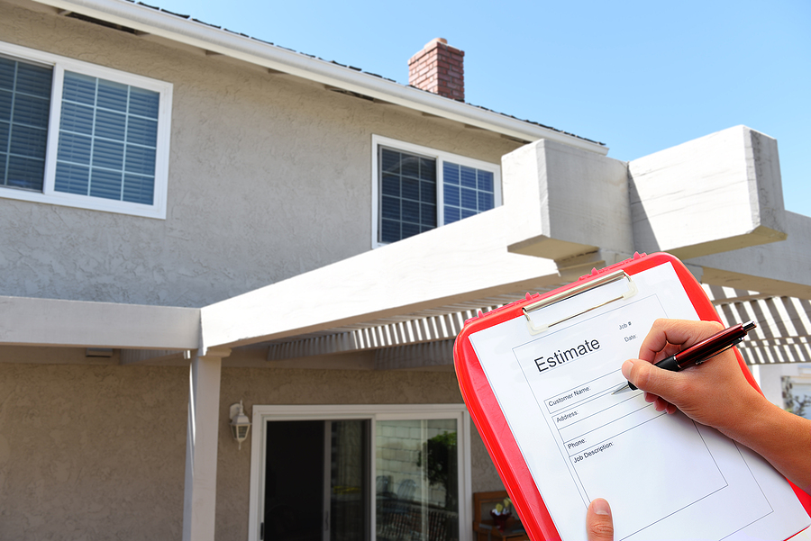 Contractor with clipboard writing an estimate for outdoor home i
